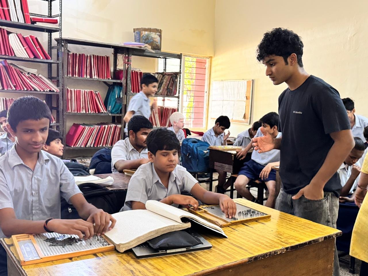 Students working with braille slates at their desks as I lead the session