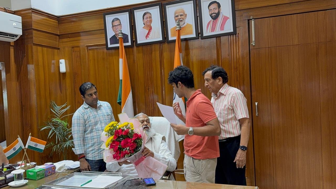 Presenting the accessibility petition to Anil Vij, who holds the bouquet in his lap