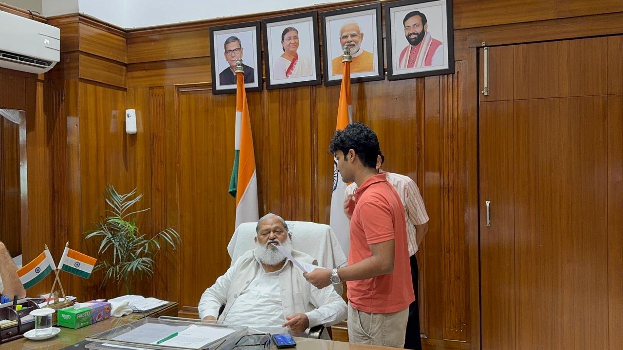 Anil Vij signing the accessibility petition, with attendees seated in the foreground
